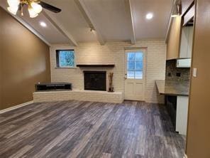 5728 Rockhill Rd, Fort Worth, TX 76112 - unfurnished living room featuring wood finished floors, a brick fireplace, beam ceiling, ceiling fan, and baseboards