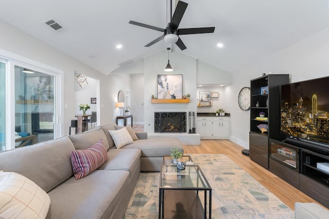 15732 Nedra Way, Dallas, TX 75248 - living room featuring light wood-style floors, ceiling fan, lofted ceiling, a lit fireplace, and baseboards