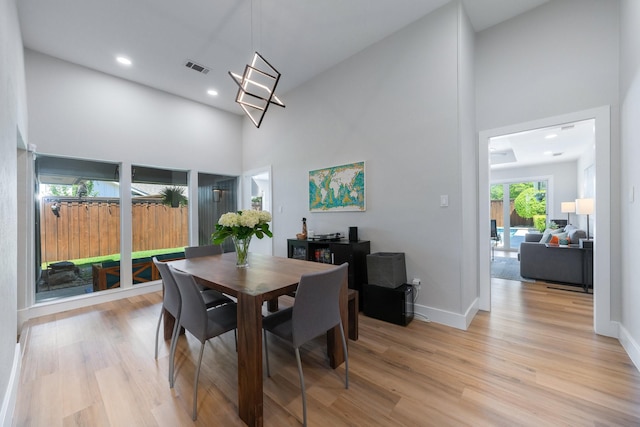 15732 Nedra Way, Dallas, TX 75248 - dining space featuring a towering ceiling, light wood-style floors, baseboards, and recessed lighting