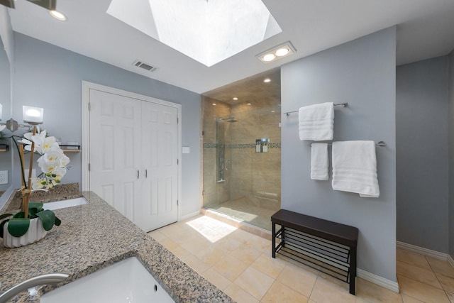 15732 Nedra Way, Dallas, TX 75248 - bathroom featuring a stall shower, tile patterned flooring, baseboards, a skylight, and double vanity