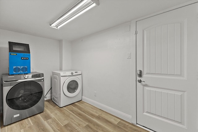 11230 Cotillion Dr, Dallas, TX 75228 - clothes washing area featuring light wood-style flooring, washing machine and dryer, and baseboards