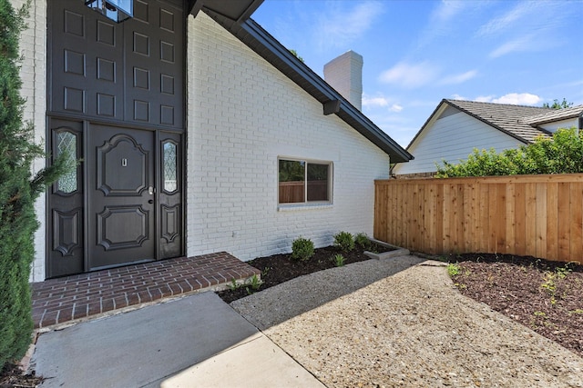 11230 Cotillion Dr, Dallas, TX 75228 - property entrance with brick siding, fence, and a chimney