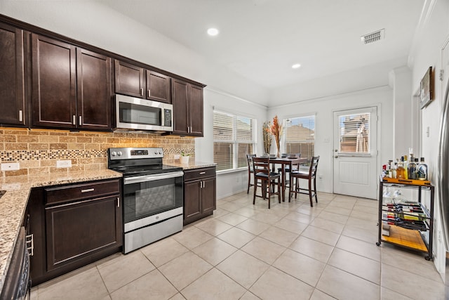 3010 Rosemount Ln, Forney, TX 75126 - kitchen with appliances with stainless steel finishes, light tile patterned floors, dark brown cabinets, backsplash, and light stone countertops