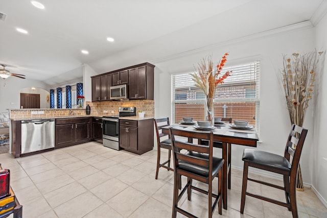 3010 Rosemount Ln, Forney, TX 75126 - kitchen featuring appliances with stainless steel finishes, dark brown cabinetry, tasteful backsplash, ceiling fan, and light stone counters
