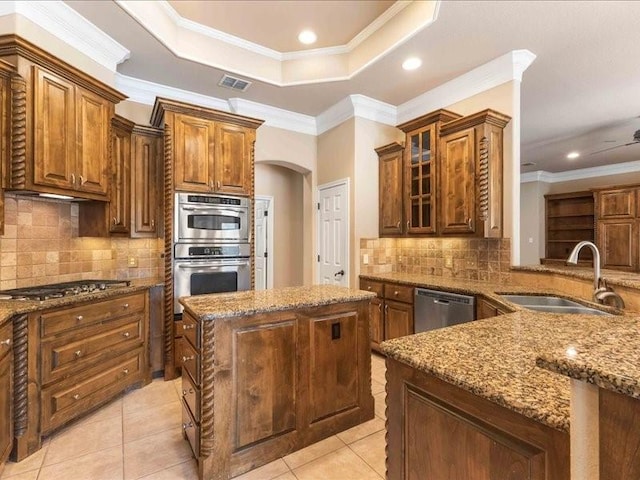 113 Winding Creek Ln, Waco, TX 76657 - kitchen featuring stainless steel appliances, a sink, crown molding, light stone counters, and a kitchen island