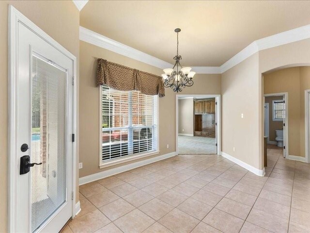 113 Winding Creek Ln, Waco, TX 76657 - unfurnished dining area with crown molding, light tile patterned flooring, a chandelier, baseboards, and arched walkways