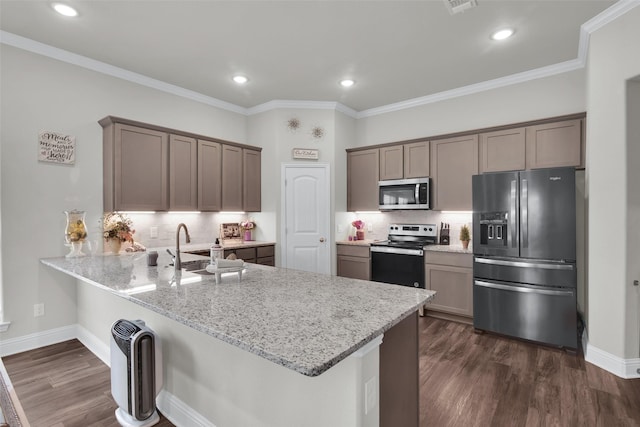 2113 Ajay Dr, Sherman, TX 75092 - kitchen featuring appliances with stainless steel finishes, a peninsula, light stone counters, tasteful backsplash, and recessed lighting