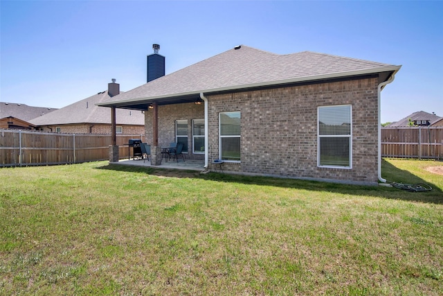 2113 Ajay Dr, Sherman, TX 75092 - back of property featuring brick siding, a patio, roof with shingles, and a chimney