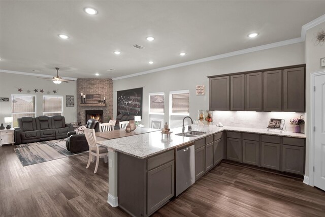 2113 Ajay Dr, Sherman, TX 75092 - kitchen with stainless steel dishwasher, a sink, a brick fireplace, ceiling fan, and dark wood-style flooring