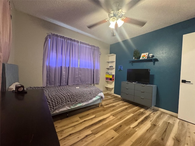 bedroom featuring wood finished floors, a textured ceiling, and ceiling fan