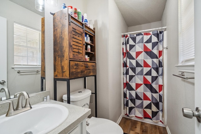 816 Red Oak Ct, Azle, TX 76020 - bathroom with toilet, wood finished floors, a shower with curtain, a textured ceiling, and vanity