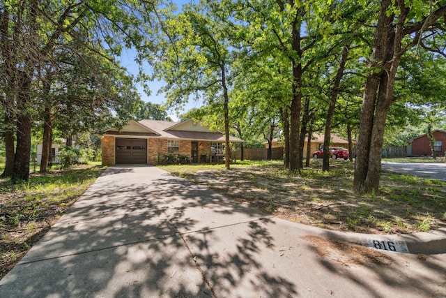 816 Red Oak Ct, Azle, TX 76020 - view of front of house with concrete driveway, brick siding, fence, and an attached garage