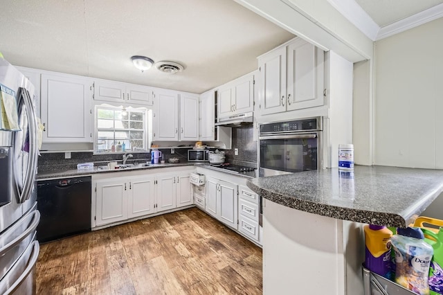 kitchen with black appliances, white cabinetry, backsplash, a sink, and crown molding