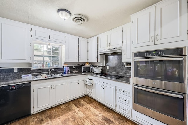 kitchen with black appliances, under cabinet range hood, a sink, white cabinetry, and a textured ceiling