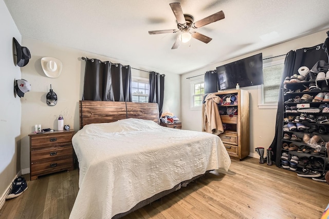 bedroom featuring light wood-style flooring, baseboards, and ceiling fan
