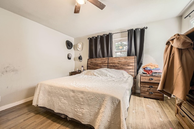 bedroom with wood-type flooring, baseboards, and a ceiling fan