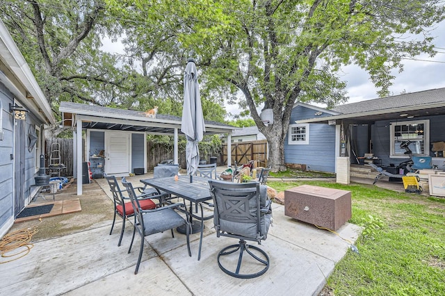 view of patio / terrace with a fenced backyard, outdoor dining area, and an outdoor structure