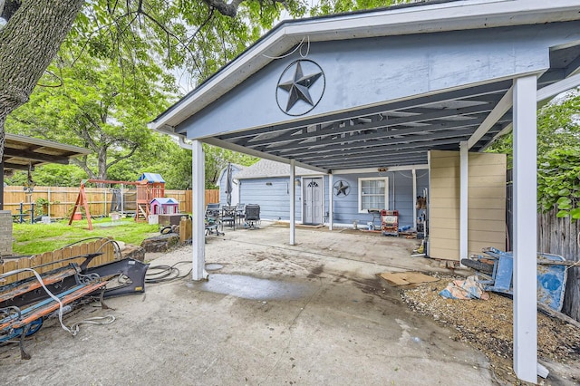 view of patio / terrace with a playground, fence, and outdoor dining space