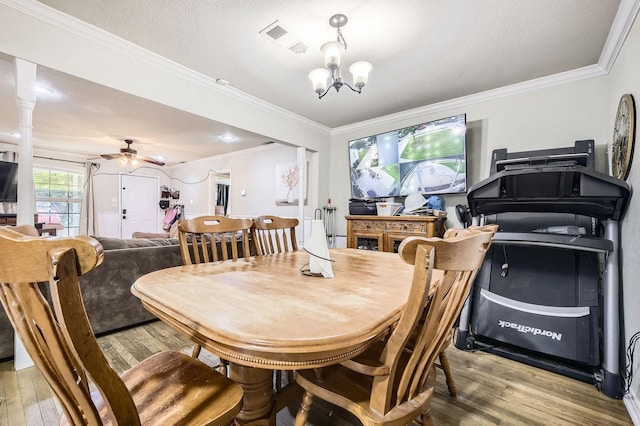 dining area with light wood-style floors, ornamental molding, a chandelier, and ceiling fan