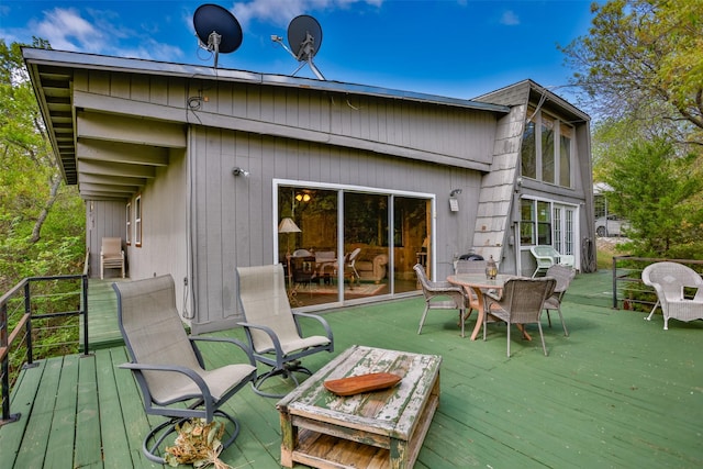 1867 Chaparral Dr, Gainesville, TX 76240 - rear view of house with a wooden deck and outdoor dining area