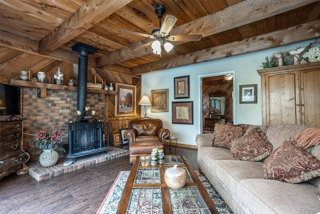 1867 Chaparral Dr, Gainesville, TX 76240 - living room with wood ceiling, beamed ceiling, a wood stove, wood finished floors, and a ceiling fan