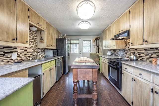 1867 Chaparral Dr, Gainesville, TX 76240 - kitchen with under cabinet range hood, appliances with stainless steel finishes, a sink, a textured ceiling, and tasteful backsplash