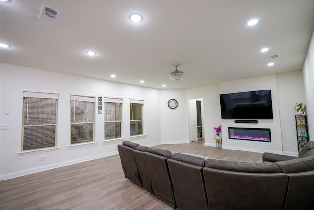 4569 Wilbarger St, Plano, TX 75024 - living room featuring a glass covered fireplace, light wood-style floors, recessed lighting, and baseboards