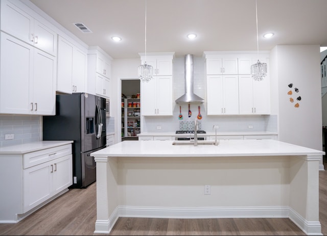 4569 Wilbarger St, Plano, TX 75024 - kitchen with wall chimney range hood, stainless steel refrigerator with ice dispenser, light wood-style floors, and backsplash