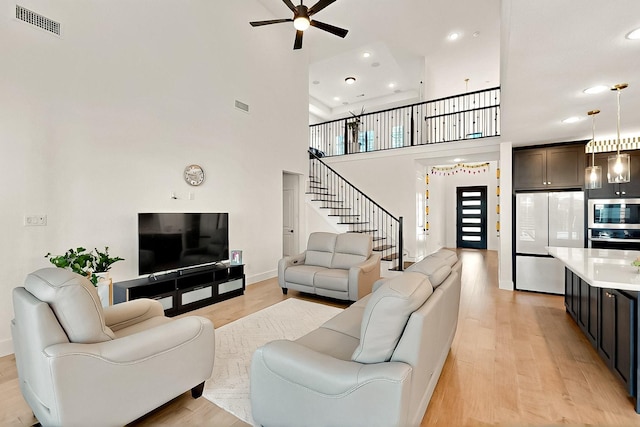 3932 Linear, Celina, TX 75078 - living area with ceiling fan, light wood-style floors, stairs, recessed lighting, and a high ceiling