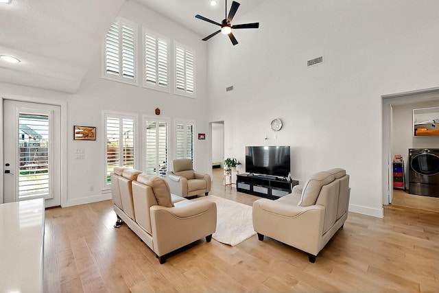 3932 Linear, Celina, TX 75078 - living area with a ceiling fan, washer / dryer, light wood-style floors, baseboards, and a high ceiling