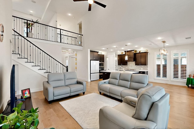 3932 Linear, Celina, TX 75078 - living room with a ceiling fan, light wood-style floors, baseboards, a towering ceiling, and recessed lighting