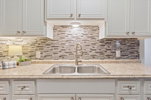 kitchen featuring a sink, light countertops, white cabinets, and tasteful backsplash