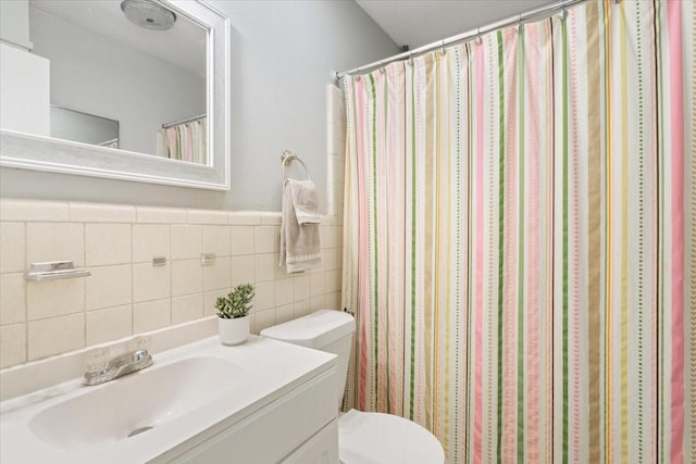 full bathroom with toilet, vanity, tile walls, and a shower with shower curtain