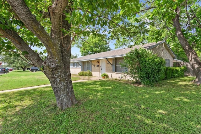 ranch-style home featuring brick siding and a front lawn