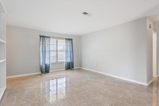 unfurnished room featuring baseboards and light tile patterned flooring