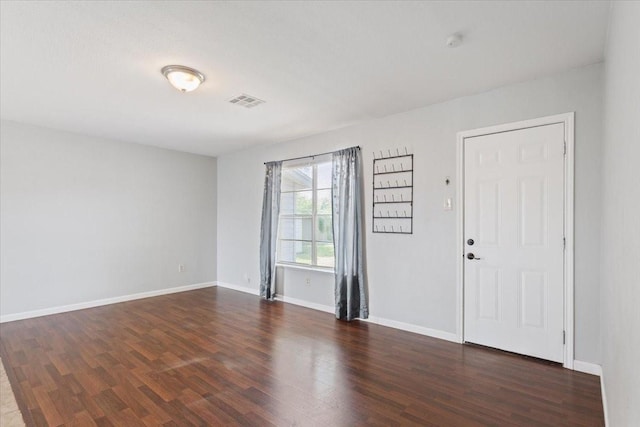 foyer entrance featuring dark wood-type flooring and baseboards