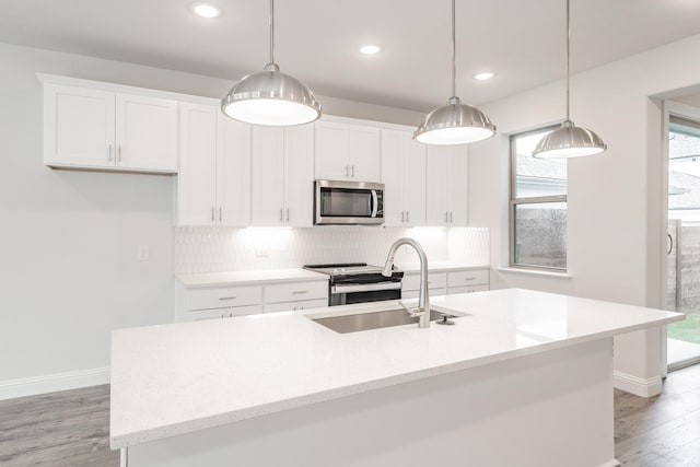 9709 Thorncrown Ln, Fort Worth, TX 76179 - kitchen with stainless steel appliances, a sink, light wood finished floors, baseboards, and white cabinetry
