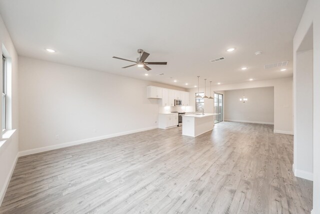 9709 Thorncrown Ln, Fort Worth, TX 76179 - unfurnished living room with light wood finished floors, recessed lighting, baseboards, a ceiling fan, and a sink