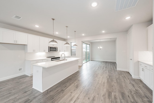 9709 Thorncrown Ln, Fort Worth, TX 76179 - kitchen with stainless steel appliances, a sink, an island with sink, tasteful backsplash, and light wood finished floors