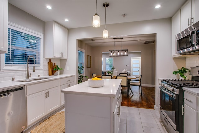 1300 Mountain Lake Rd, Dallas, TX 75224 - kitchen with appliances with stainless steel finishes, a sink, a center island, decorative backsplash, and white cabinets