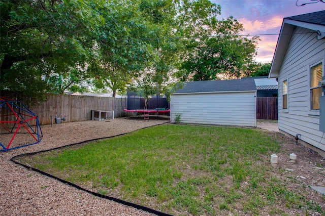 1300 Mountain Lake Rd, Dallas, TX 75224 - yard at dusk featuring a trampoline, an outbuilding, and a shed