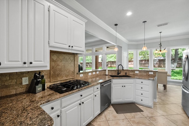 1304 Brook Arbor Dr, Mansfield, TX 76063 - kitchen with a sink, appliances with stainless steel finishes, a peninsula, healthy amount of natural light, and ornamental molding