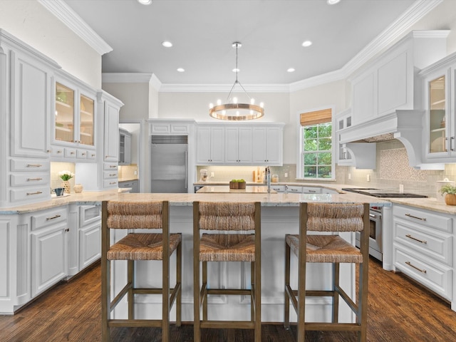5916 Orchard Park Dr, Frisco, TX 75034 - kitchen featuring high end appliances, white cabinetry, a chandelier, tasteful backsplash, and a breakfast bar area