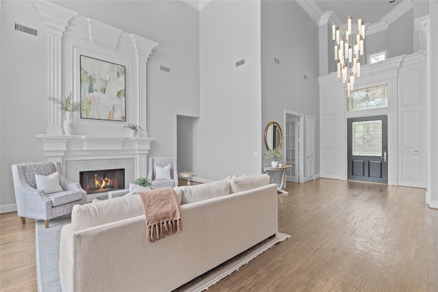 5916 Orchard Park Dr, Frisco, TX 75034 - living area featuring a chandelier, crown molding, wood finished floors, baseboards, and a towering ceiling