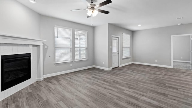 1913 Brindle St, Northlake, TX 76247 - unfurnished living room with ceiling fan, baseboards, recessed lighting, a glass covered fireplace, and wood finished floors