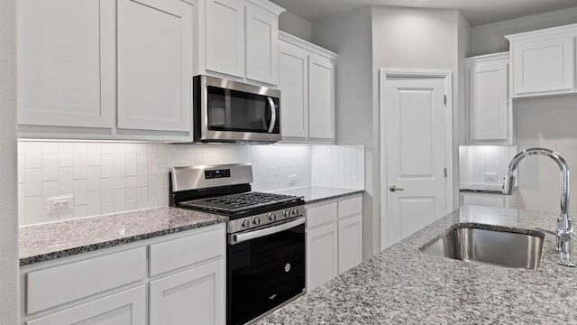 1913 Brindle St, Northlake, TX 76247 - kitchen with stainless steel appliances, a sink, white cabinets, light stone countertops, and decorative backsplash