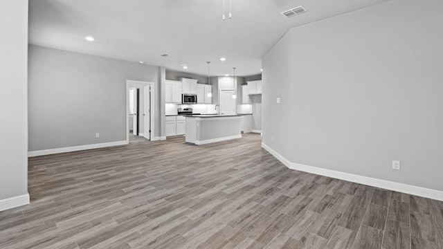 1913 Brindle St, Northlake, TX 76247 - unfurnished living room featuring baseboards, light wood-type flooring, a sink, and recessed lighting