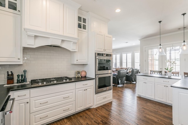 1132 Mount Ln, Rhome, TX 76078 - kitchen with appliances with stainless steel finishes, dark countertops, white cabinets, crown molding, and tasteful backsplash
