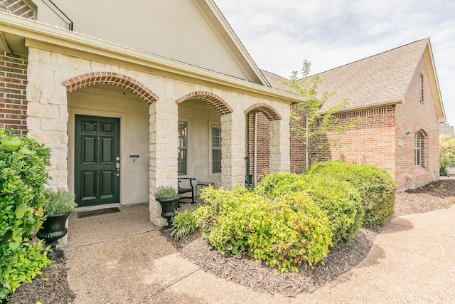 1132 Mount Ln, Rhome, TX 76078 - property entrance with brick siding, a porch, stone siding, and roof with shingles