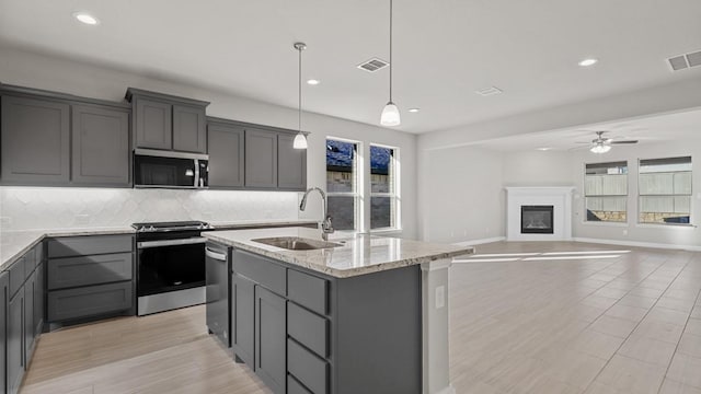 1900 Stetson St, Northlake, TX 76247 - kitchen featuring appliances with stainless steel finishes, a sink, gray cabinetry, backsplash, and ceiling fan
